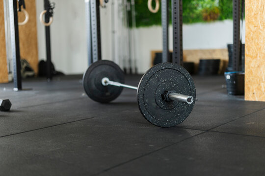Barbell with weight plates on gym floor ready for workout