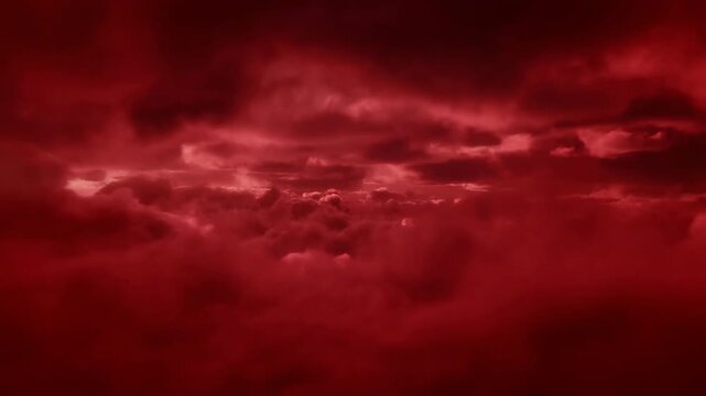 Dense crimson cloud layers drift and reshape beneath a dark red sky, revealing brighter glowing gaps through the center as rolling forms create an atmospheric abstract cloudscape