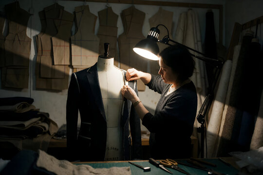 Tailor pinning jacket on dress form tilt shift