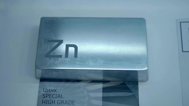 A bar made of chemically pure zinc is presented at the exhibition. Closeup. Shot in motion