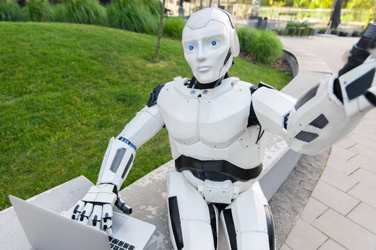 Futuristic android holding laptop and taking selfie