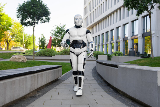Cybernetic humanoid robot carrying takeaway coffee cup
