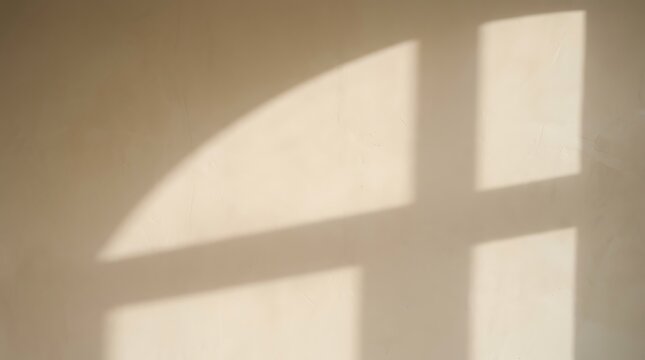 Geometric window shadow cast on a beige interior wall with copy space