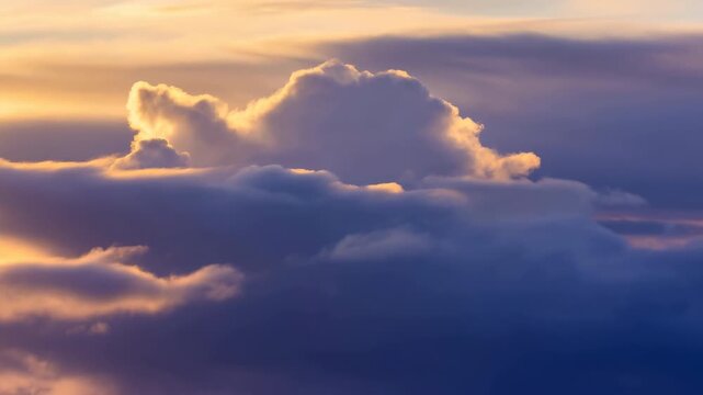 Towering cumulus clouds drift across layered blue cloudscape while warm golden light outlines billowing edges and changing formations beneath softly glowing sky