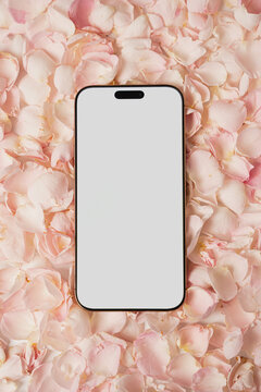 Phone mockup positioned on delicate pink flower petals. Feminine romantic backdrop for digital presentation