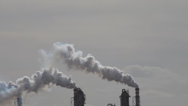 Air Pollution Concept - Industrial factory smokestacks billowing heavy smoke with sky background 4k Video footage