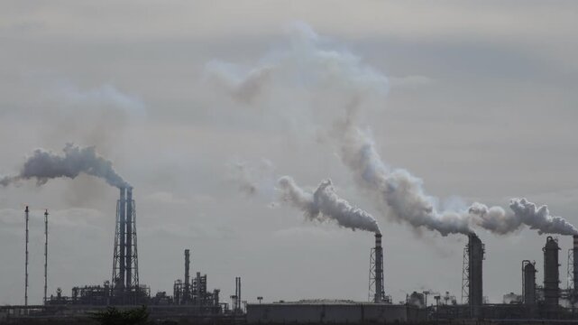 Industrial plant chimneys emitting heavy smoke and air pollution, concept of climate change, carbon emissions, and environmental degradation 4k Video footage