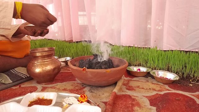 Indian Priest Performing Traditional Hindu Hawan Ritual and Offering Ahuti in Sacred Fire During Festival