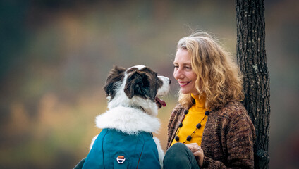 Fototapeta premium happy woman with dogs playing outdoors in autumn forest