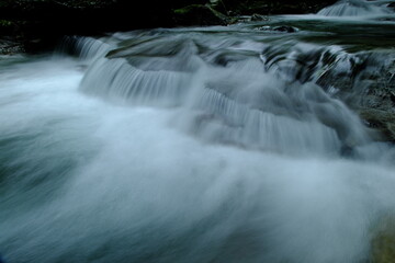 Long exposure of a beautiful cascading mountain stream with silky smooth water texture © Nobby