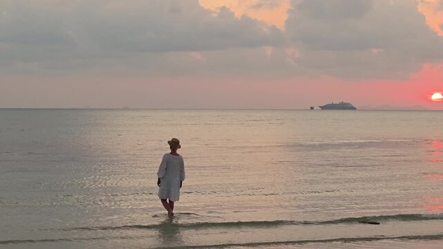 Woman Standing in Shallow Sea at Sunset