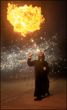 Devil masked performer breathing fire during correfoc festival