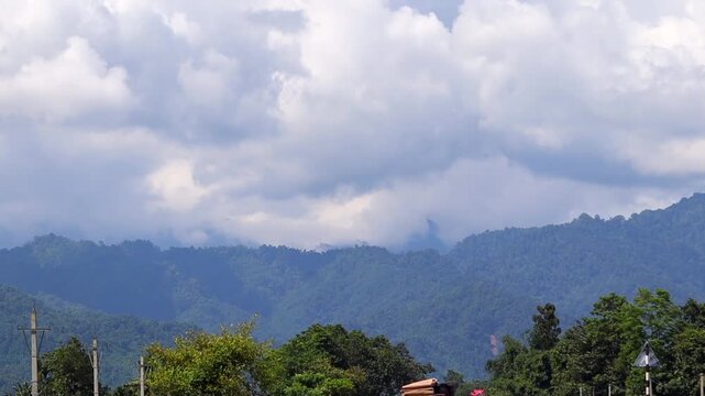 Forest-Covered Mountain Range Beneath Dramatic Clouds
