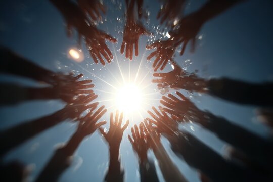 Multiple hands reach toward bright sunlight, creating a visual metaphor of unity, aspiration, and collective hope, while also suggesting themes of community and cooperation
