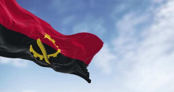 Close-up of Angola national flag waving in the wind on a clear day