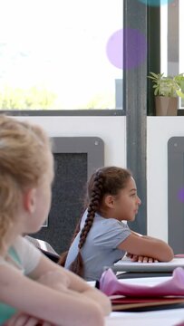 Vertical video: Braided pupil sitting class raising hand pointing to teacher after floating circles