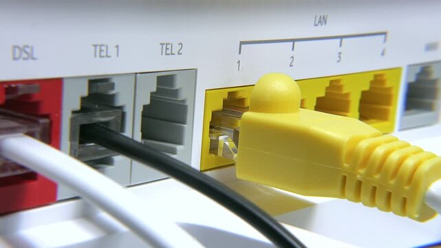 A person connects various colored cables to a modem for internet access. The focus is on the connections at the back of the device. Yellow, black, and white cables are visible.