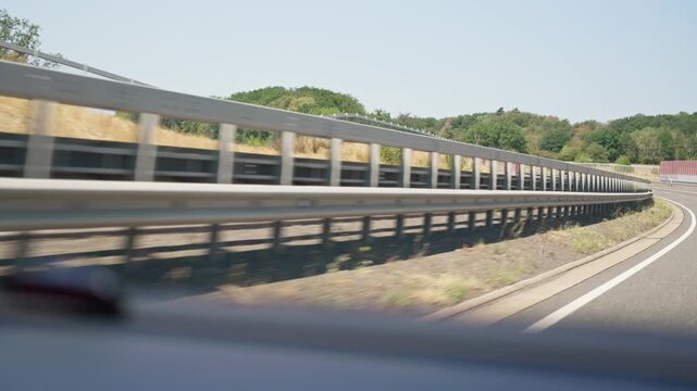 Speeding highway guardrail view from car slow motion a bumpy road