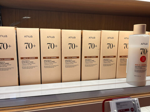 A display of Anua skincare products organized neatly on a shelf. The products are predominantly beige, with clear labels. They emphasize anti-aging features. The textures are smooth and appealing.