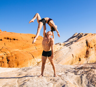 Acrobatic yoga pose on rock formations in USA desert