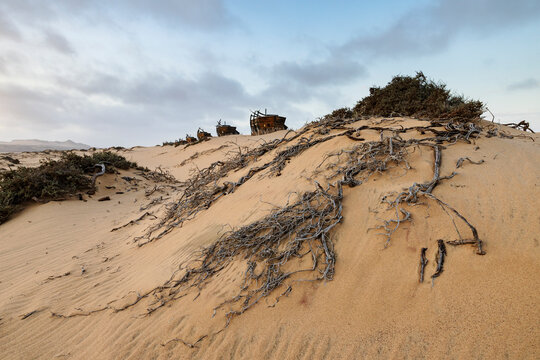 Shipwreck lodge ruins on sand dunes at Sunset in Namibia