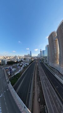 TEL AVIV, ISRAEL - SEPTEMBER 21, 2026: High aerial view of completely empty Ayalon Highway with people riding bicycles and rollerblades during Yom Kippur.