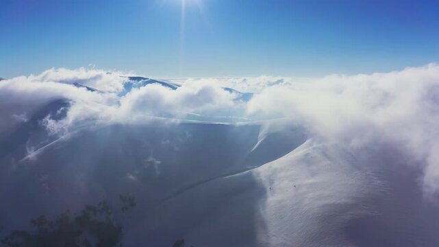 An extraordinary mountain valley covered with fluffy clouds at winter sunset