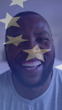 Vertical video: Man facing cam smiling then laughing as tap activating drifting star filter for ads