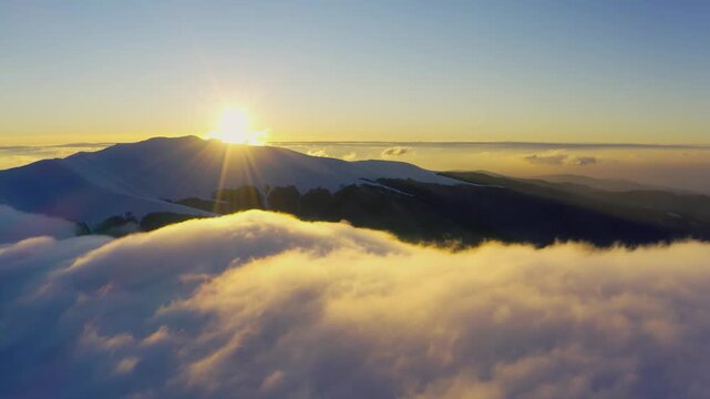Wonderful view of extraordinary cloudy valley and bright orange sunset