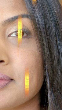 Vertical video: Woman reacting to gold streaks moving over face, revealing smile for cosmetics