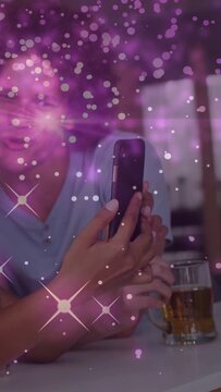 Vertical video: Lady raising phone showing friend screen at bar with mug for ads purple overlaying