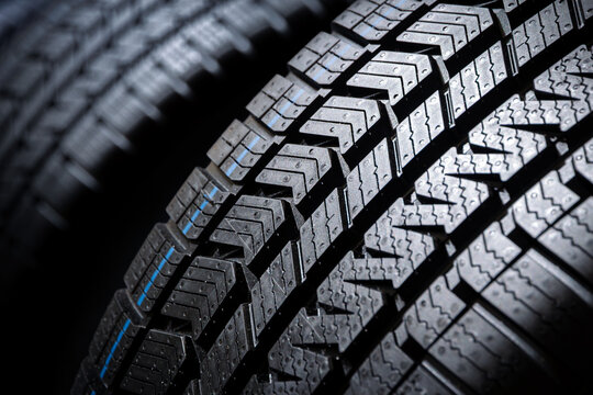Close-up of a modern car tire showing its detailed tread pattern.