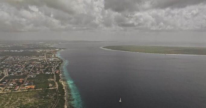 Bonaire Caribbean Netherlands Aerial v55 high rising flyover above Hato, revealing Kralendijk, turquoise shoreline, Klein Bonaire and dramatic clouds - Shot with 5k Camera - Feb 3rd 2024
