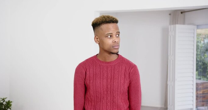 High speed photography for dynamic scenes, man in red sweater standing indoors, looking down with th