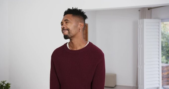 High speed photography for dynamic scenes, smiling man in red sweater standing indoors, looking up w