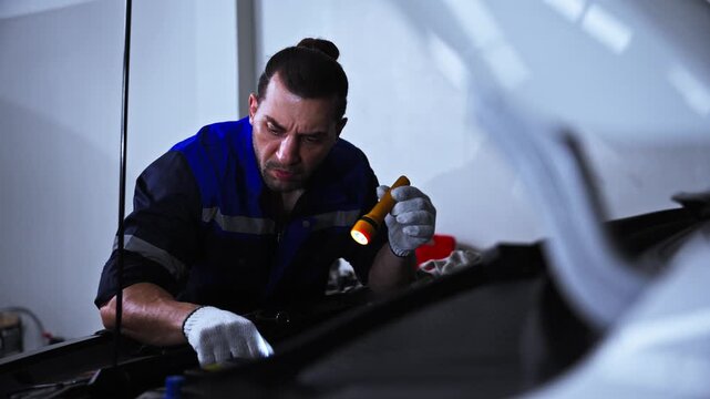 Automotive Repair Team Working Together on Vehicle Maintenance. Group of professional automotive technicians working together around a vehicle during a repair and maintenance procedure. Concept of tea