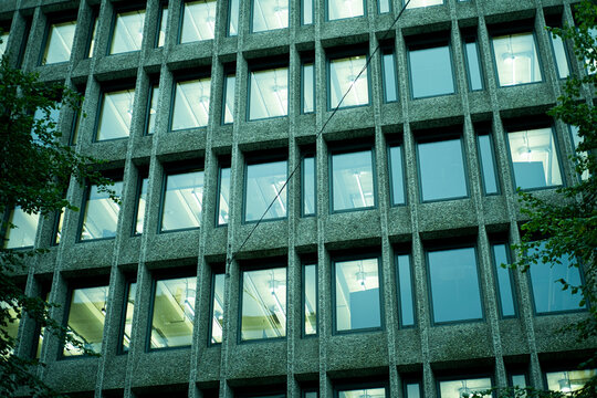 Concrete office facade with repeated windows and grid pattern, showing modern urban architecture through the repeated grid across the concrete facade