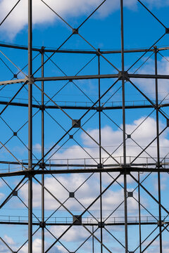Geometric steel framework creates a transparent facade against blue sky, with modern structural architecture repeating the geometric framework across the facade