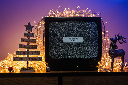 Vintage CRT television, no signal static, glowing lights and festive holiday decorations