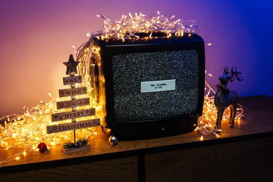 Vintage CRT television, no signal static, glowing lights and festive holiday decorations