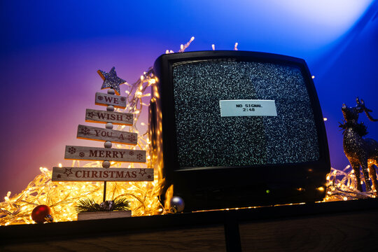 Vintage CRT television, no signal static, glowing lights and festive holiday decorations