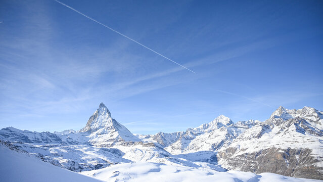 Panoramic view of snow covered Swiss Alps and Matterhorn under blue sky in winter