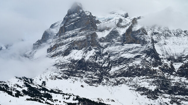 Majestic snowy mountain peak wrapped in clouds and mist Grindelwald Switzerland