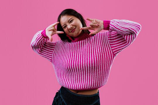 Young woman showing rock n roll gesture smiling