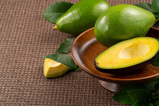Fresh avocado with sliced and diced pieces over woven bamboo background