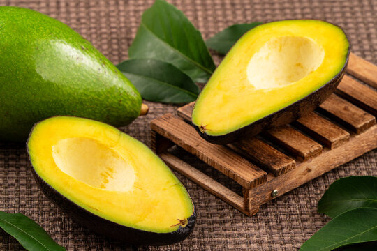 Fresh avocado with sliced and diced pieces over woven bamboo background