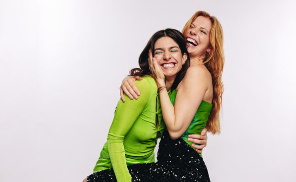 Two friends hugging and laughing in studio
