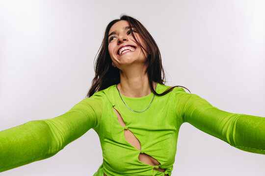 Woman taking a joyful selfie in studio
