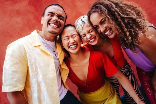 Diverse group of friends laughs together in urban setting