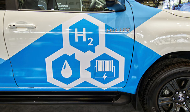 Toyota hilux hydrogen fuel cell vehicle displaying h2, water, and power icons at an auto show in hanover